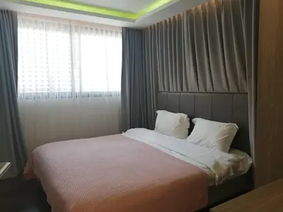 a bedroom with a large bed with a window at Bangkok Asok Circle REIN Sukhumvit 12#2BR&3BR#Pool&Gym#Near Terminal 21 in Bangkok