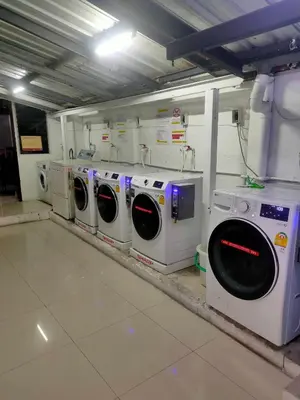 a laundry room with a row of washing machines at PRL Place in Bangkok