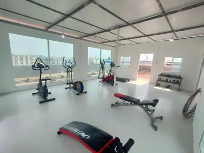 a gym with several exercise equipment in a room with windows at PRL Place in Bangkok