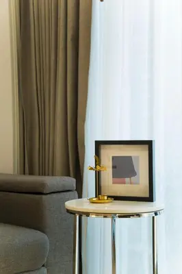 a table with a picture on it next to a chair at Sukhumvit 11#Luxury#Pool#Gym#BTS Nana&MRT Sukhumvit#1BR#Max4ppl in Bangkok