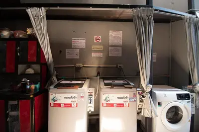 three washing machines and a washer and dryer in a room at Loftel 22 Hostel in Bangkok