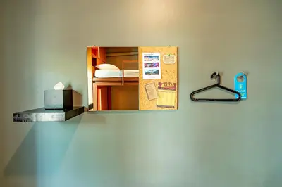 a mirror on the wall of a room with a bed at Loftel 22 Hostel in Bangkok