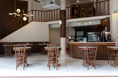 a restaurant with tables and chairs and a bar at Loftel 22 Hostel in Bangkok