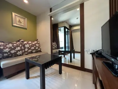 a living room with a couch and a table at Silom Forest Exclusive Residence in Bangkok