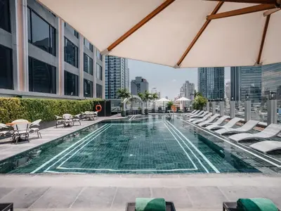 a swimming pool on the roof of a building with chairs at Aira Hotel Bangkok Sukhumvit 11 in Bangkok