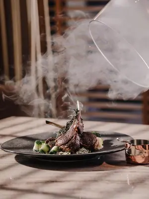a plate of food on a table with smoke at Aira Hotel Bangkok Sukhumvit 11 in Bangkok