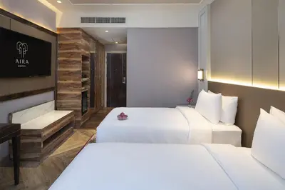 a hotel room with two beds and a tv at Aira Hotel Bangkok Sukhumvit 11 in Bangkok