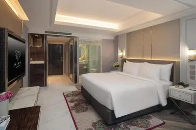 a bedroom with a large white bed and a television at Aira Hotel Bangkok Sukhumvit 11 in Bangkok