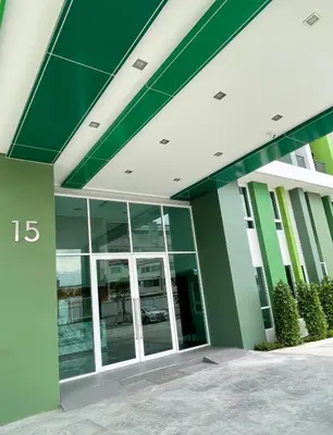 a green and white building with glass windows at Sabai Residence @Bangyai in Nonthaburi