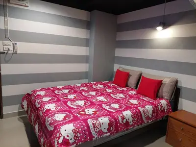 a bedroom with a red bed with gray and white stripes at BB GuestHouse in Ban Zong Katiam