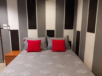a bedroom with a bed with two red pillows at BB GuestHouse in Ban Zong Katiam