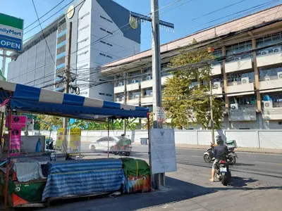 a person riding a motorcycle next to a food cart at BB GuestHouse in Ban Zong Katiam
