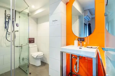 a bathroom with a toilet and a sink and a shower at SureStay by Best Western Iconic Ari-Jatujak in Bangkok
