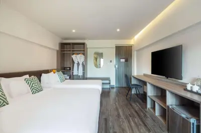 a hotel room with a bed and a flat screen tv at SureStay by Best Western Iconic Ari-Jatujak in Bangkok