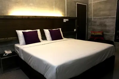 a bedroom with a large bed with purple pillows at Bangkok 68 in Bangkok