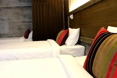 a hotel room with three beds in a room at Bangkok 68 in Bangkok