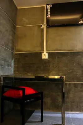 a red chair in a room with a wall at Bangkok 68 in Bangkok