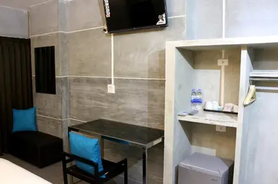 a room with a table and a chair and a television at Bangkok 68 in Bangkok