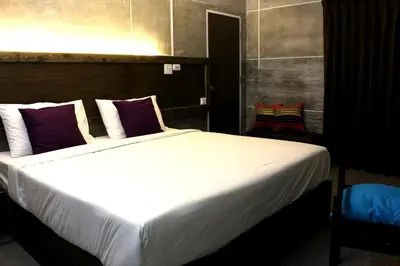 a bedroom with a large bed with purple and white pillows at Bangkok 68 in Bangkok