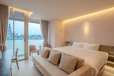 a hotel room with a large bed and a large window at Inn a day in Bangkok