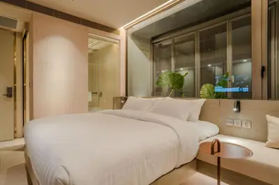 a bedroom with a large white bed and a window at Inn a day in Bangkok