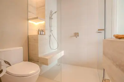 a bathroom with a toilet and a glass shower at Inn a day in Bangkok