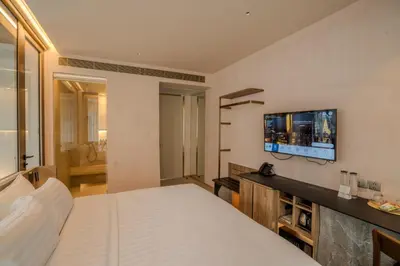 a bedroom with a bed and a tv on the wall at Inn a day in Bangkok