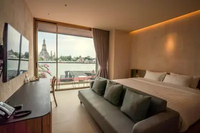 a hotel room with a bed and a couch and a window at Inn a day in Bangkok
