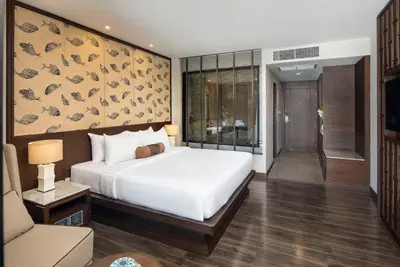 a bedroom with a large white bed and a couch at Casa Nithra Bangkok in Bangkok
