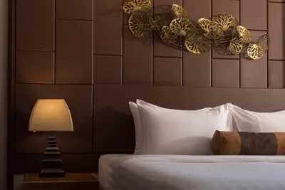 a bedroom with a bed with a lamp and a headboard at Casa Nithra Bangkok in Bangkok