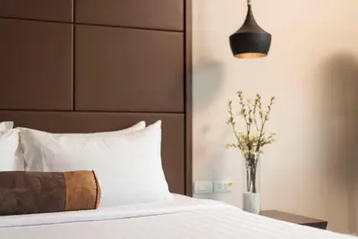 a bedroom with a bed and a vase of flowers at Casa Nithra Bangkok in Bangkok