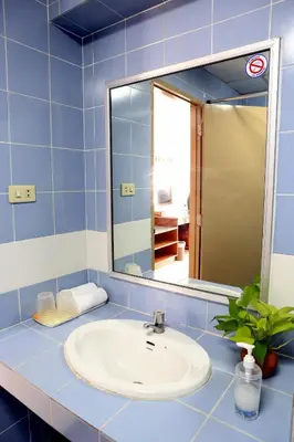 a bathroom with a sink and a mirror at L.A. Tower Hotel in Bangkok