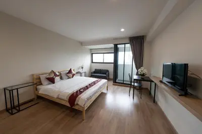 a bedroom with a bed and a flat screen tv at L.A. Tower Hotel in Bangkok
