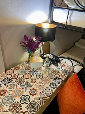 a table with a lamp and flowers on it at Lemon Siam Hostel Free Breakfast in Bangkok