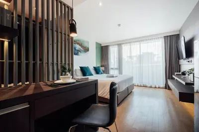 a bedroom with a bed and a desk with a chair at Montana Bangkok Hotel & Residence in Bangkok