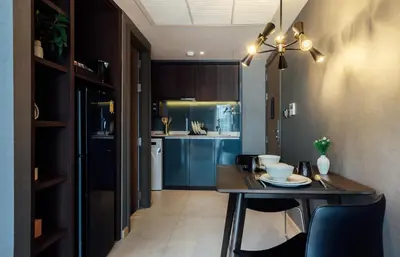 a kitchen with a table and a dining room at Montana Bangkok Hotel & Residence in Bangkok