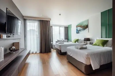 a hotel room with two beds and a flat screen tv at Montana Bangkok Hotel & Residence in Bangkok