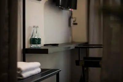 a glass bottle sitting on a shelf in a bathroom at Tim Mansion in Bangkok
