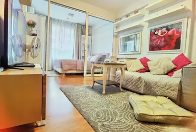 a living room with a couch and a table at Rama9 Cozy Apartment in Bangkok