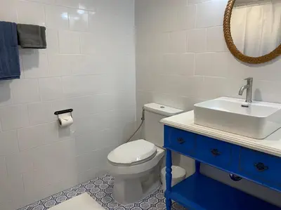 a bathroom with a white toilet and a sink at Grasshopper Bed and Cafe in Pak Kret