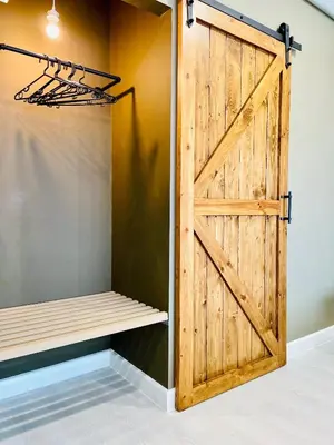 a sliding barn door in a room with a closet at Grasshopper Bed and Cafe in Pak Kret