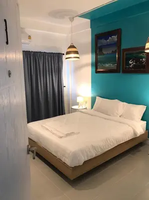 a bedroom with a bed with a blue wall at Baan Suandao Wat Arun in Bangkok