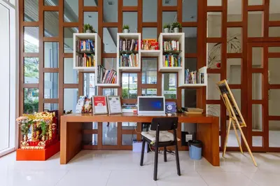 a room with a desk with a laptop and bookshelves at Siamaze Hostel in Bangkok