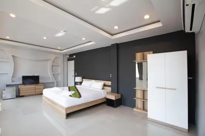 a bedroom with a white bed and a television at 185@Surawong Residence in Bangkok