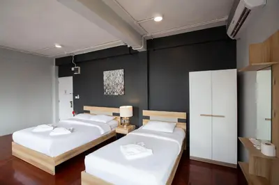 two beds in a room with black walls at 185@Surawong Residence in Bangkok