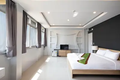 a bedroom with a large bed and a television at 185@Surawong Residence in Bangkok