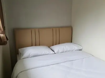 a bed with white sheets and pillows in a room at Bangkok Check Inn @Chareon Krung in Bangkok