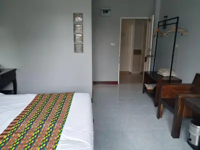 a bedroom with a bed and a table and a desk at Platinum Place in Bangkok