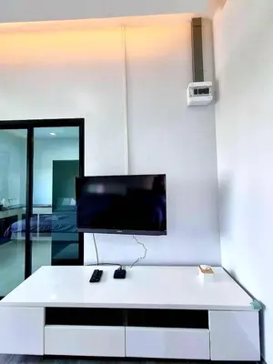 a white living room with a tv on a wall at Aqua Residences อควา เรสซิเดนซ์ ห้องพักใหม่ให้เช่า ติดรถไฟฟ้าสถานีวุฒากาศ in Bangkok