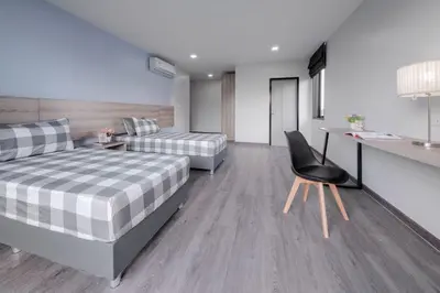 a bedroom with two beds and a chair in it at Aqua Residences อควา เรสซิเดนซ์ ห้องพักใหม่ให้เช่า ติดรถไฟฟ้าสถานีวุฒากาศ in Bangkok